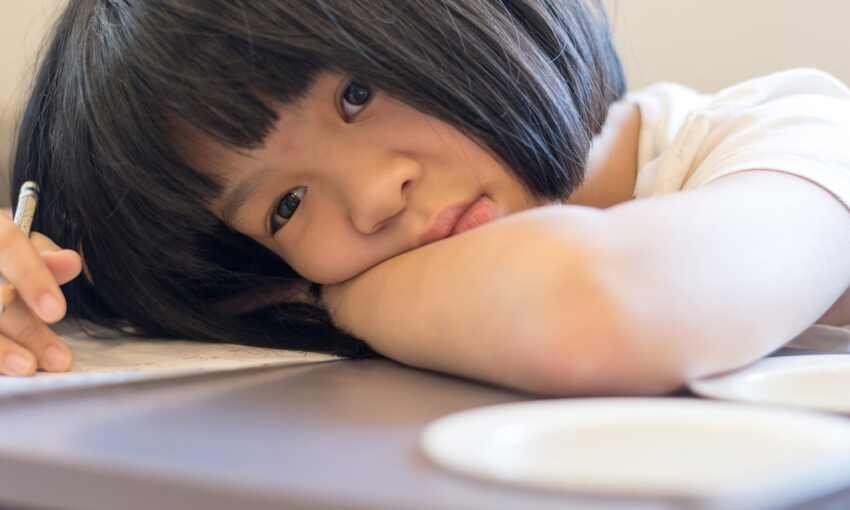 girl leaning head on desk