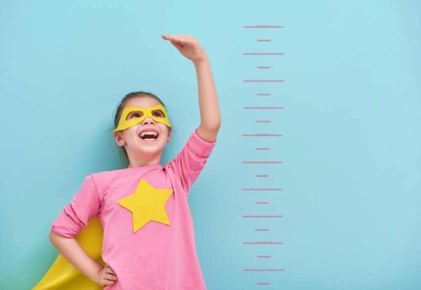 superhero child measured against scale