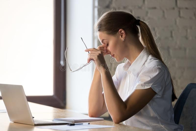 tired businesswoman taking off glasses suffering eye strain tired businesswoman taking off glasses suffering eye strain 157931246
